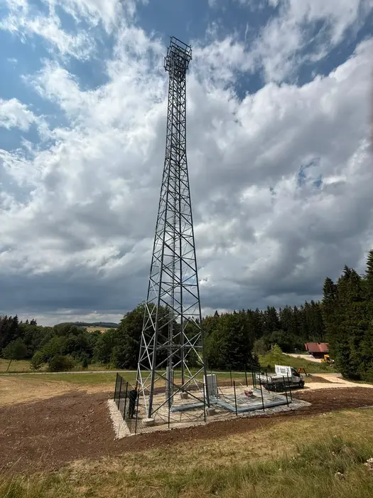 Fertiggestellter Mobilfunkstandort mit Gittermast und Technikfläche